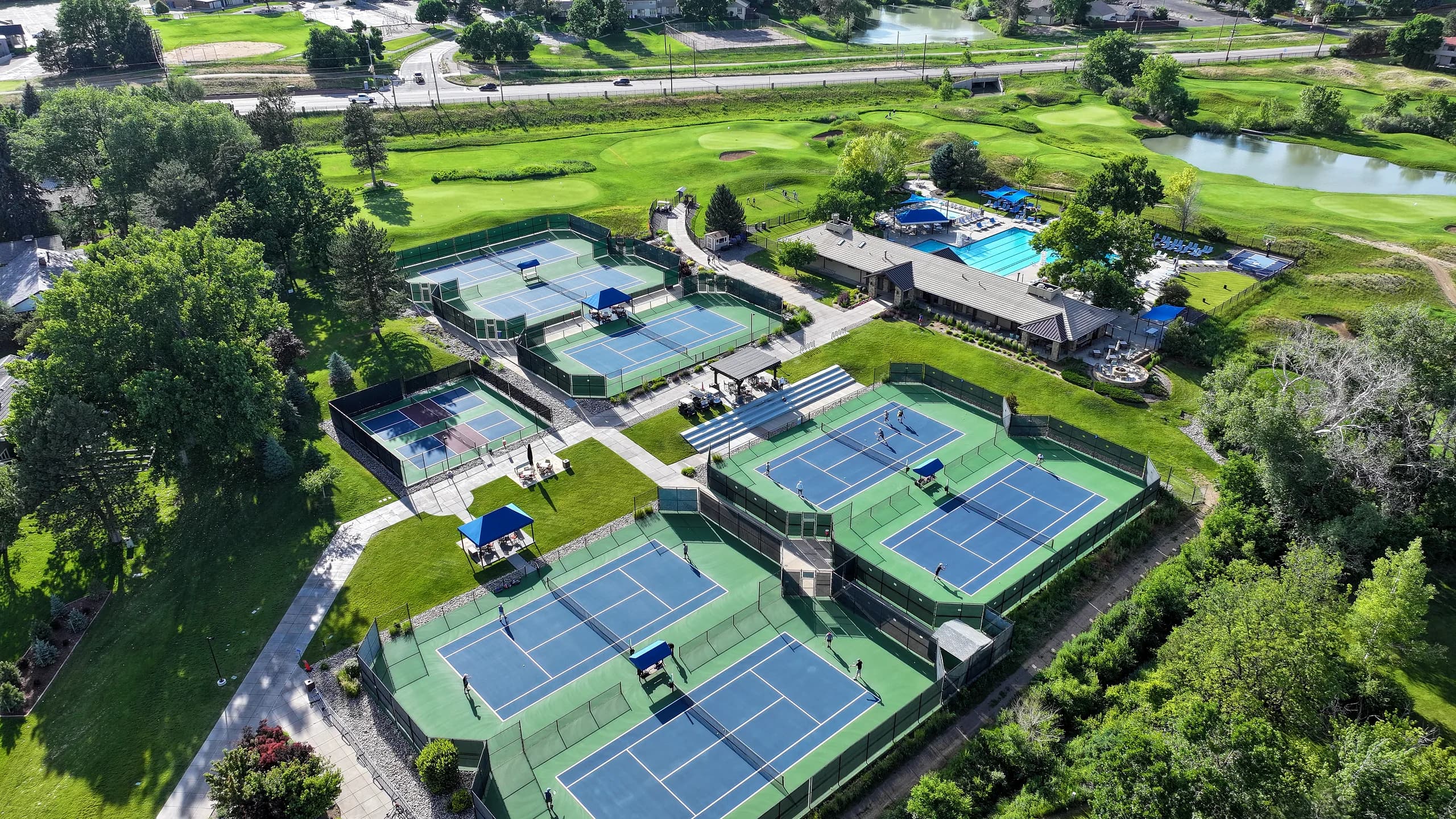 Aerial of a partner club racquet and pool complex busy with morning play