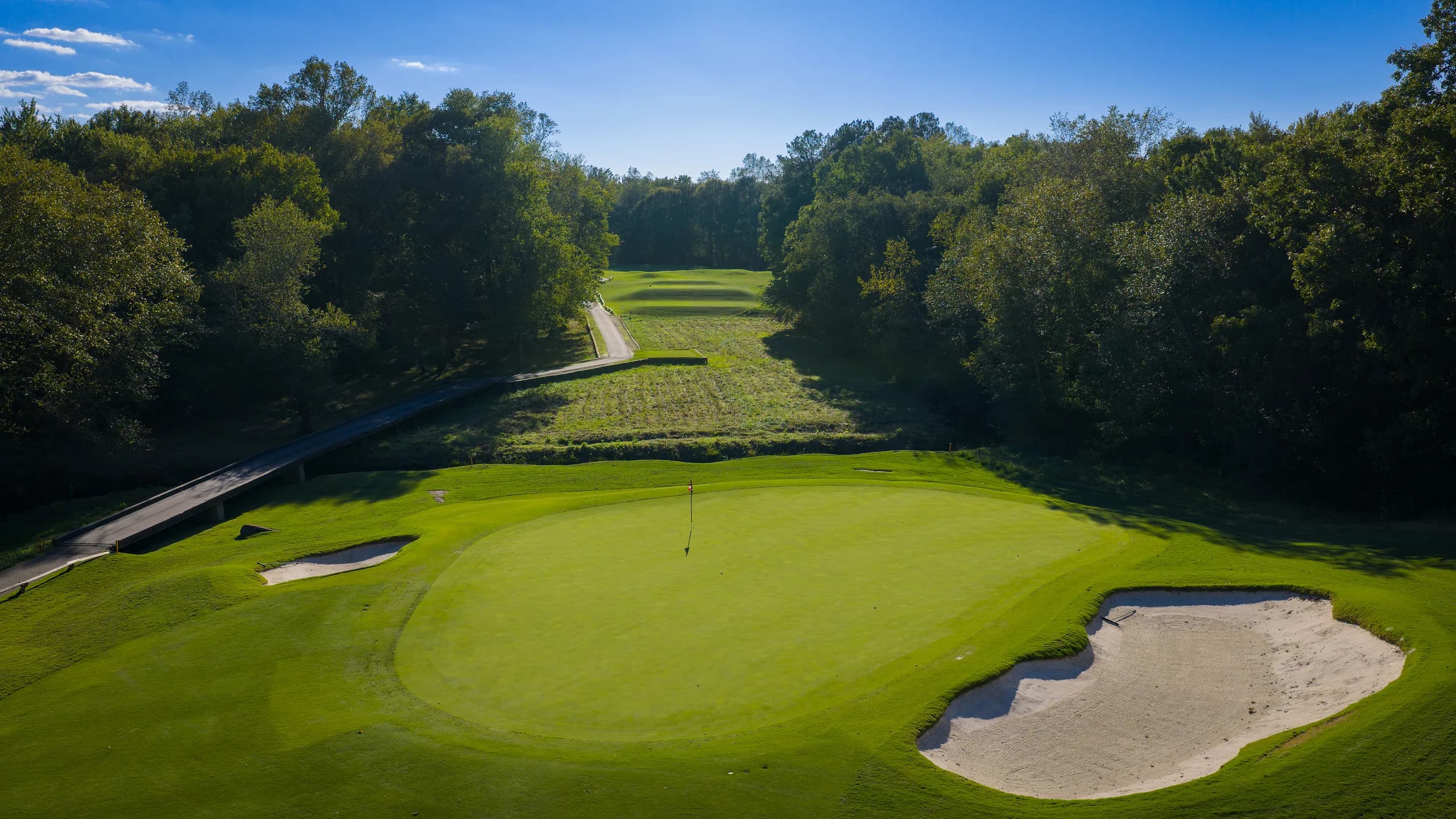 Long tree-corridor hole with a large bunker guarding the right side